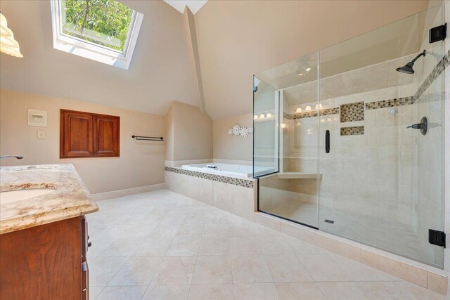 bathroom with vanity, lofted ceiling with skylight, separate shower and tub, and tile patterned flooring