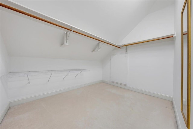 walk in closet featuring light colored carpet and vaulted ceiling