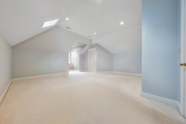 additional living space with light carpet and vaulted ceiling with skylight