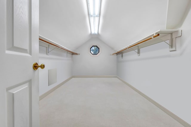 walk in closet featuring lofted ceiling and light carpet