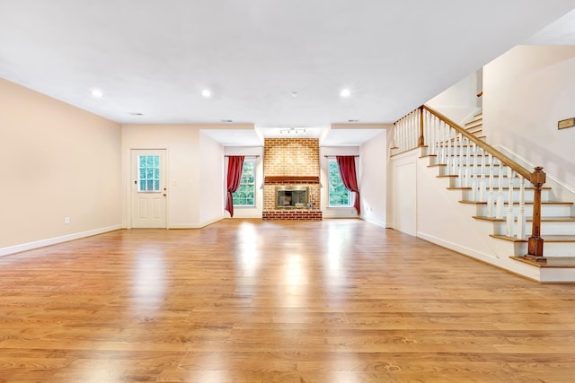 unfurnished living room with a fireplace and light hardwood / wood-style floors