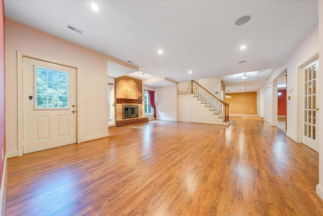 unfurnished living room featuring light wood-type flooring and a fireplace