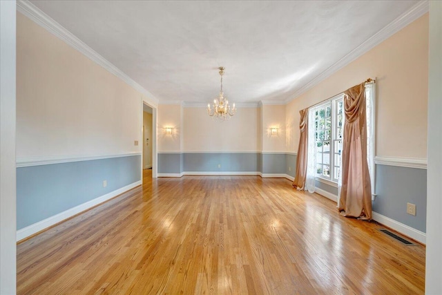 unfurnished room featuring crown molding, an inviting chandelier, and light wood-type flooring