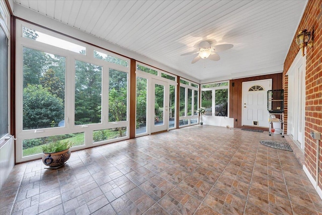 unfurnished sunroom with ceiling fan