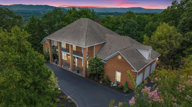 aerial view at dusk featuring a mountain view