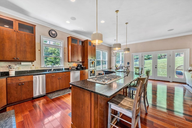 kitchen with tasteful backsplash, stainless steel appliances, dark hardwood / wood-style flooring, and plenty of natural light