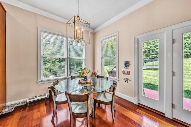 dining area featuring an inviting chandelier, crown molding, wood-type flooring, and a healthy amount of sunlight