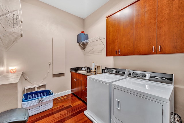 laundry room with dark wood-type flooring, sink, cabinets, and separate washer and dryer