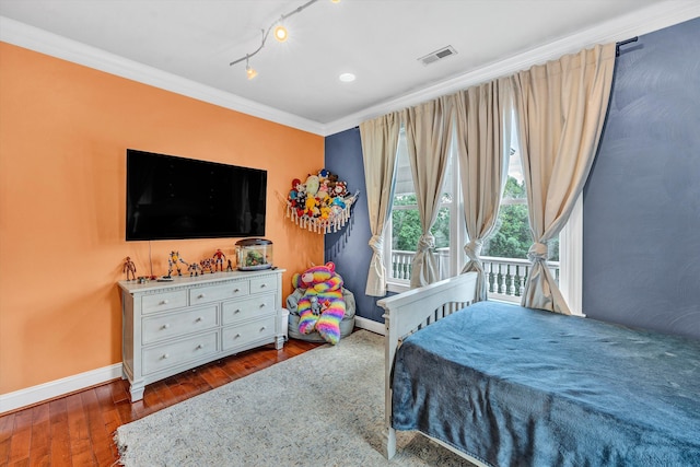 bedroom featuring crown molding, dark wood-type flooring, and rail lighting