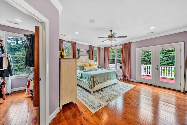 bedroom with access to exterior, ceiling fan, hardwood / wood-style flooring, and multiple windows