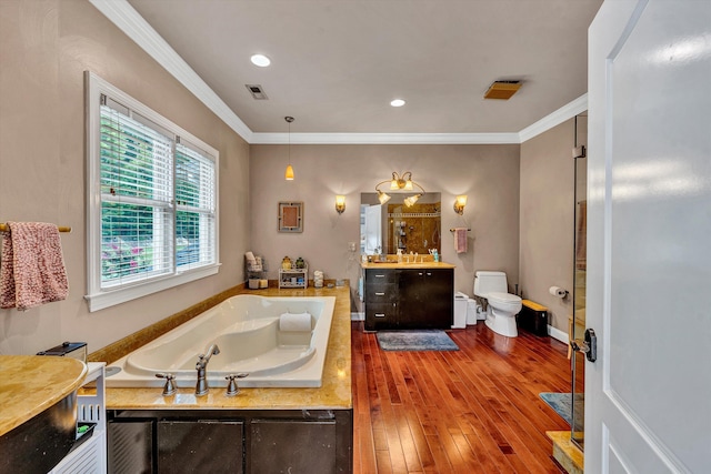 bathroom featuring crown molding, toilet, hardwood / wood-style floors, a bathing tub, and vanity