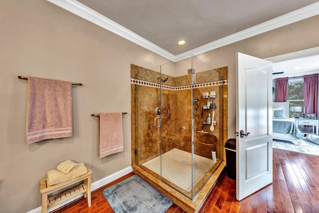 bathroom featuring an enclosed shower, ornamental molding, and wood-type flooring