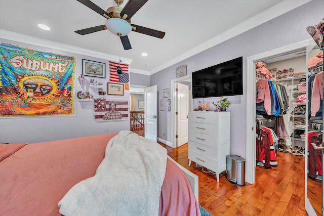 bedroom featuring wood-type flooring, ornamental molding, a closet, and ceiling fan