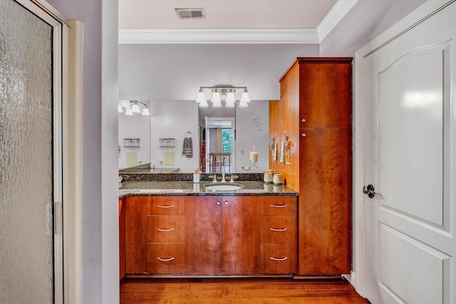 bathroom with ornamental molding, vanity, and wood-type flooring