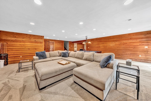 carpeted living room with wood walls