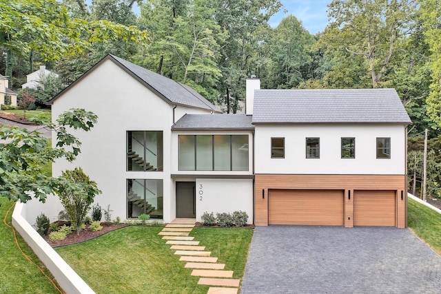 view of front of house with a garage and a front lawn