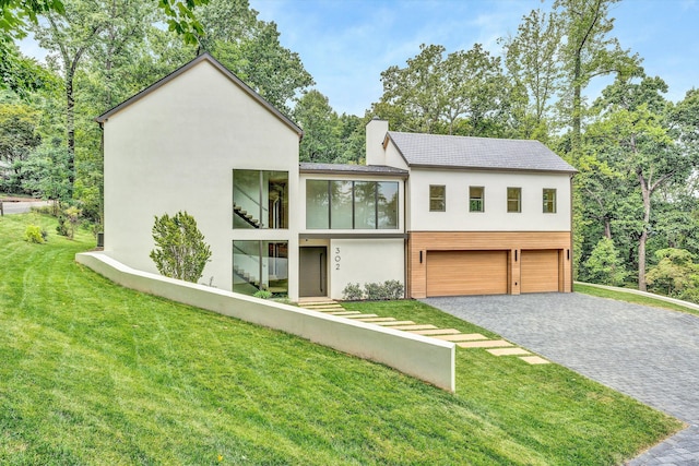 view of front of home with a garage and a front lawn