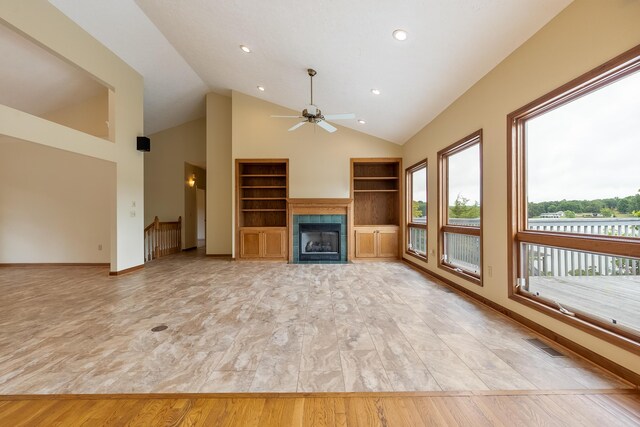 unfurnished living room featuring light hardwood / wood-style floors, plenty of natural light, and a tile fireplace