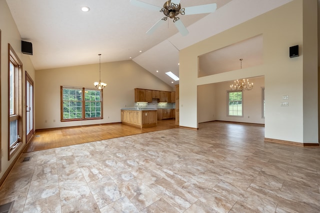 unfurnished living room featuring ceiling fan with notable chandelier, high vaulted ceiling, and light hardwood / wood-style floors