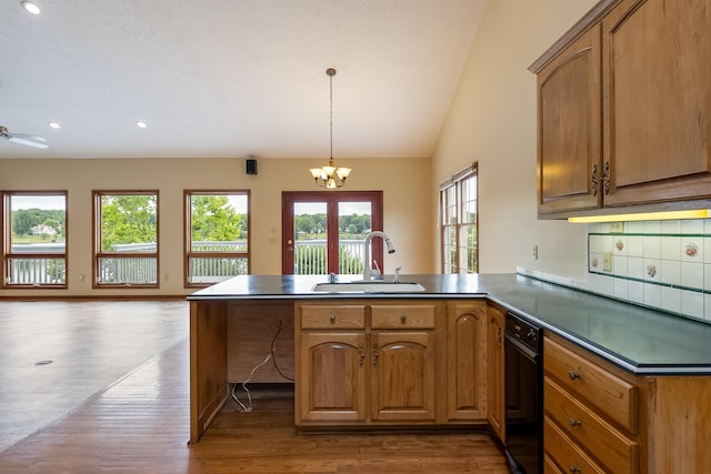 kitchen featuring sink, light hardwood / wood-style floors, kitchen peninsula, pendant lighting, and lofted ceiling