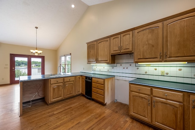 kitchen with decorative light fixtures, an inviting chandelier, tasteful backsplash, sink, and hardwood / wood-style flooring