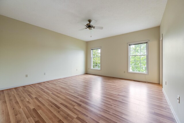 unfurnished room with light wood-type flooring, ceiling fan, and a textured ceiling