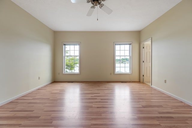 spare room featuring hardwood / wood-style floors, a wealth of natural light, and ceiling fan