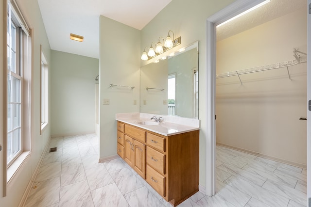 bathroom featuring a wealth of natural light, vanity, and tile patterned floors