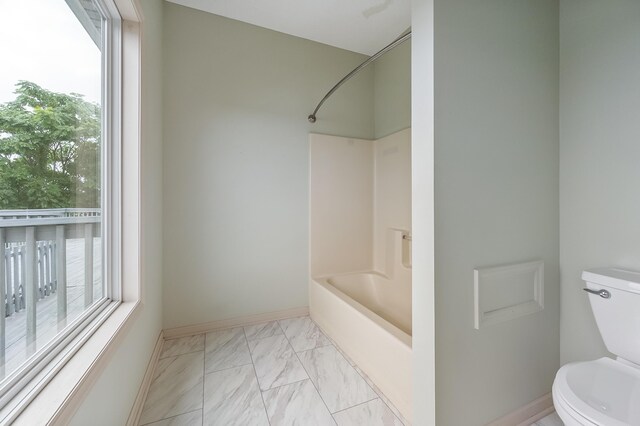 bathroom with tile patterned flooring, toilet, and bathtub / shower combination