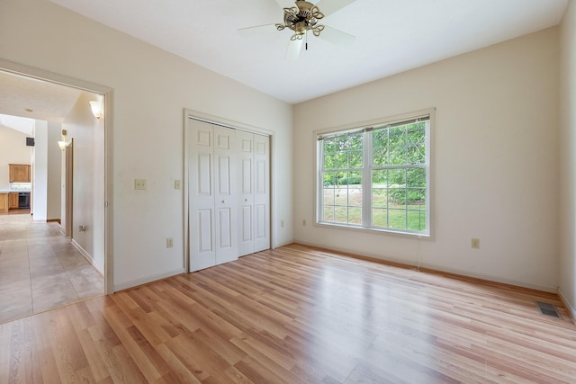 unfurnished bedroom with light hardwood / wood-style flooring, ceiling fan, and a closet