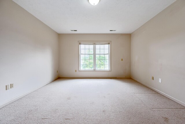 unfurnished room with a textured ceiling and carpet floors