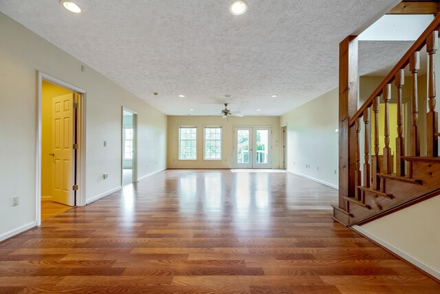 unfurnished living room featuring a textured ceiling, ceiling fan, and hardwood / wood-style flooring