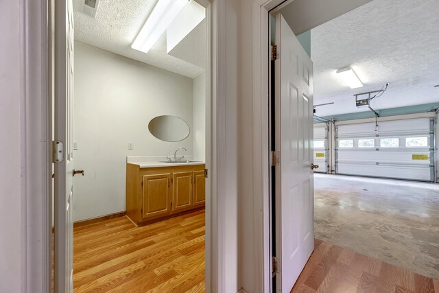 hall featuring sink and a textured ceiling