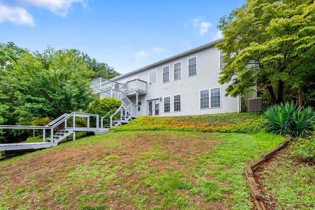 back of house featuring a wooden deck and a lawn