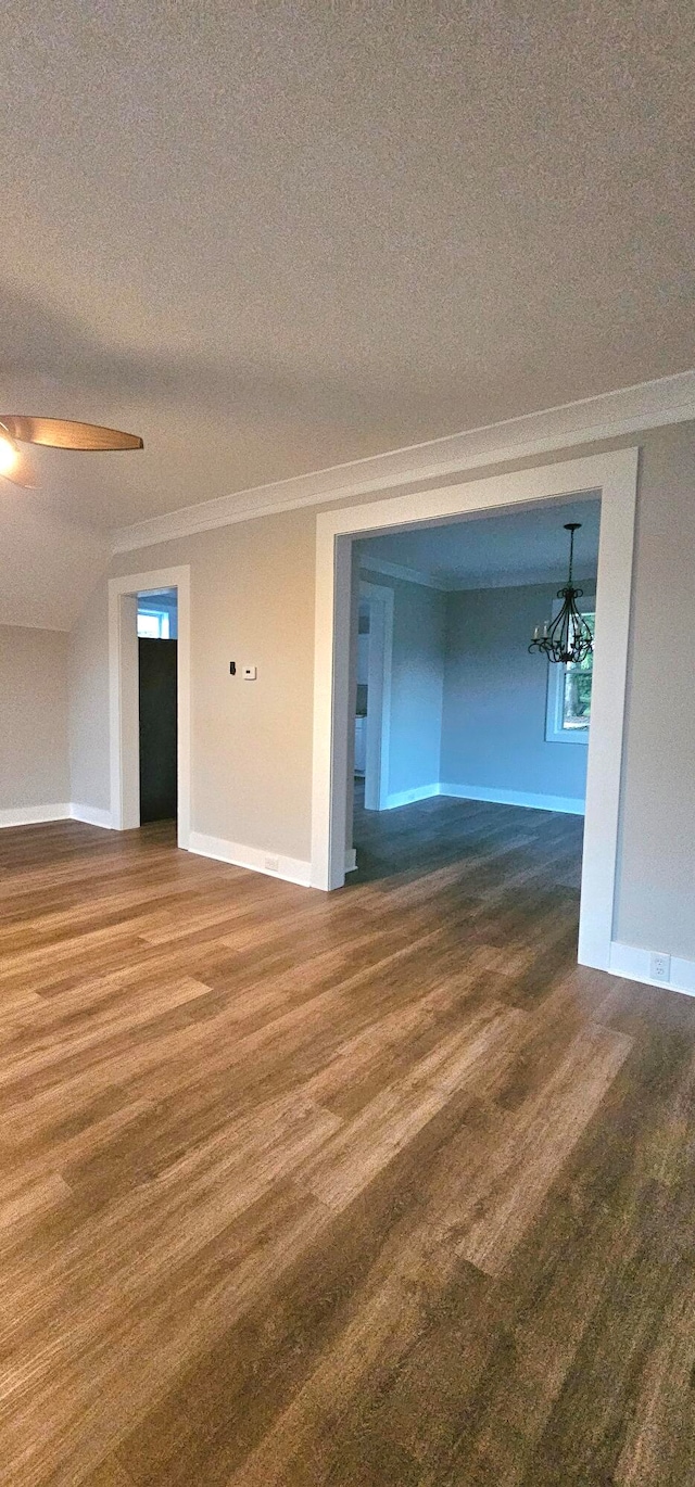 spare room featuring wood-type flooring, a textured ceiling, and an inviting chandelier