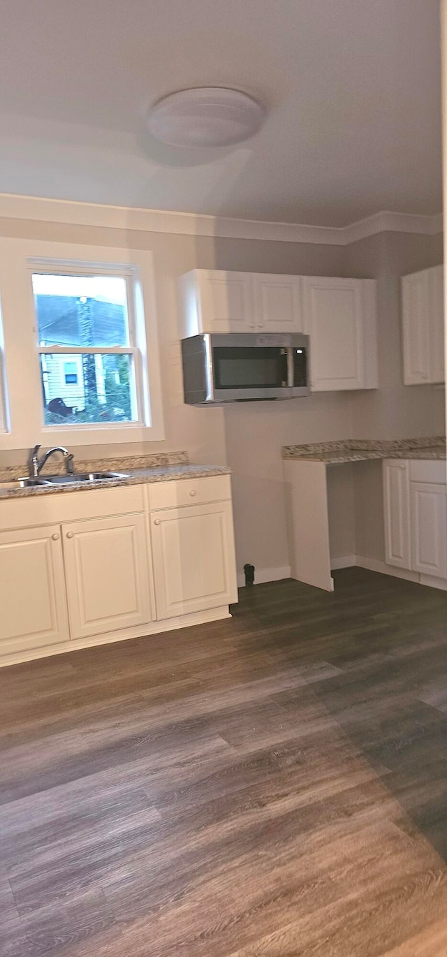 kitchen featuring sink, white cabinets, dark wood-type flooring, and ornamental molding