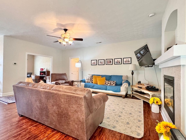 living room with ceiling fan and dark hardwood / wood-style flooring