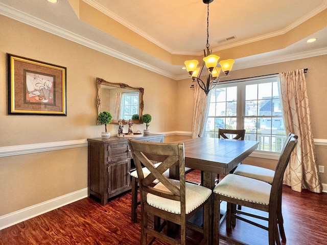 dining area with dark hardwood / wood-style floors, ornamental molding, and a tray ceiling