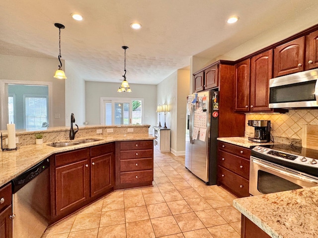 kitchen with stainless steel appliances, sink, light stone countertops, light tile patterned floors, and hanging light fixtures