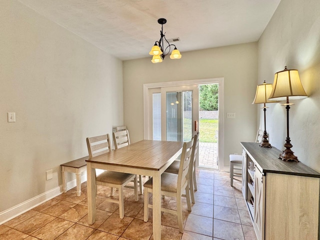 dining space with light tile patterned floors and an inviting chandelier