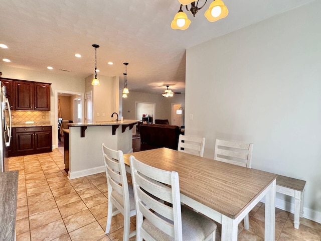 tiled dining space with ceiling fan and sink