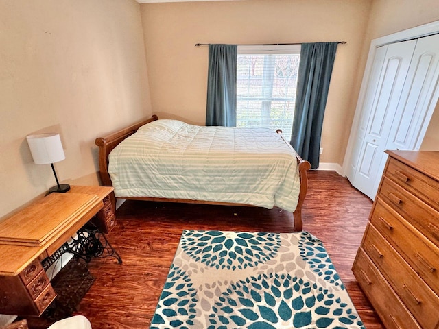 bedroom with dark wood-type flooring and a closet