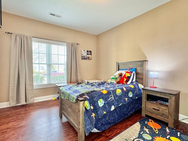 bedroom with dark hardwood / wood-style flooring