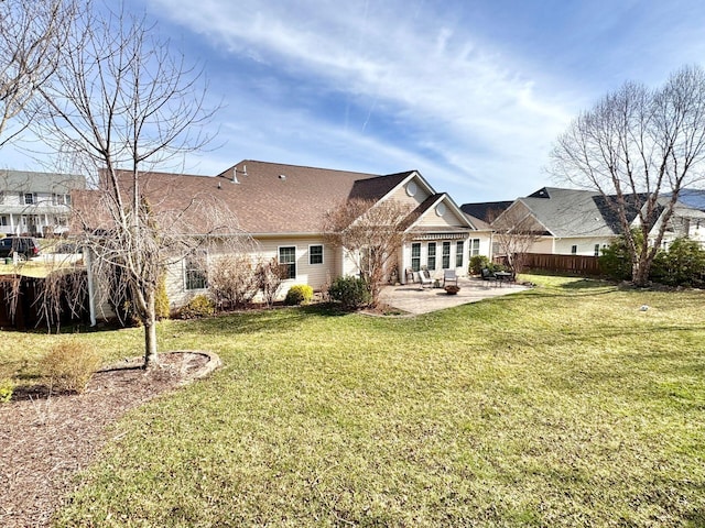 back of property with a lawn and a patio