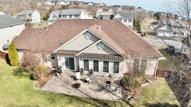 back of house featuring a lawn, a patio area, and a garage