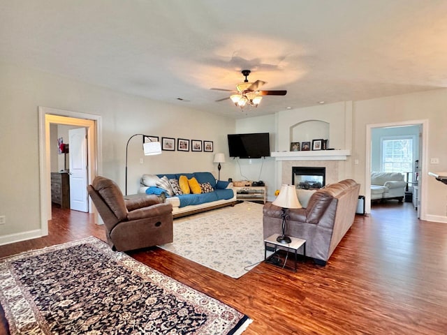 living room with hardwood / wood-style floors, a tile fireplace, and ceiling fan