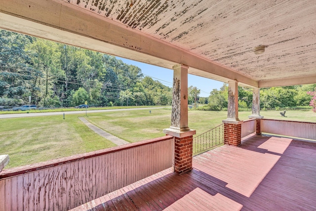 wooden deck featuring a lawn