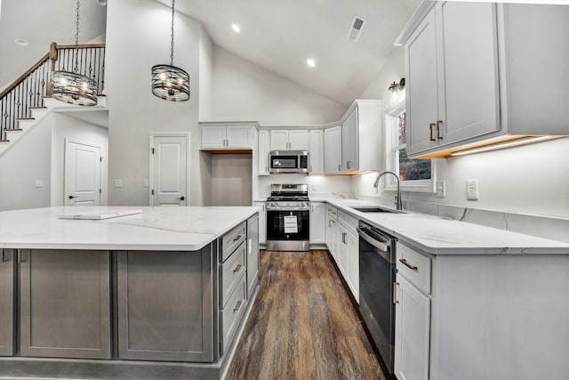 kitchen featuring appliances with stainless steel finishes, high vaulted ceiling, hanging light fixtures, and sink