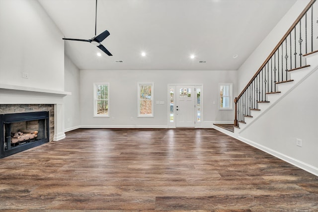 unfurnished living room featuring a stone fireplace, ceiling fan, high vaulted ceiling, and dark wood-type flooring