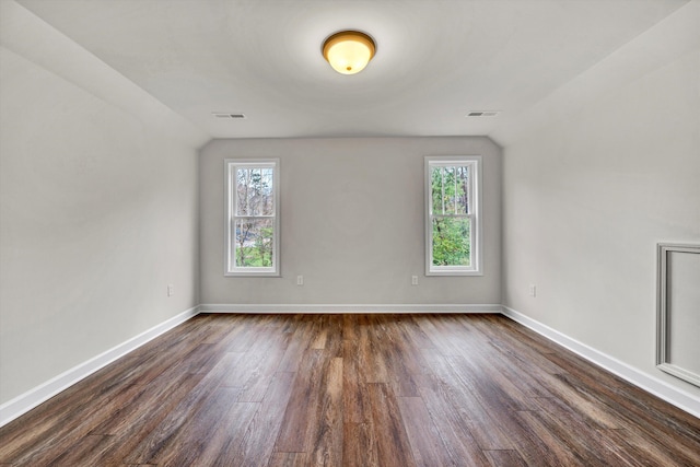 bonus room with a healthy amount of sunlight, lofted ceiling, and dark wood-type flooring